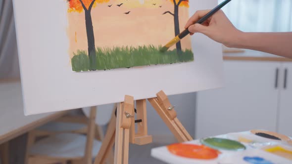 Asian young talented woman artist coloring on painting board in house.