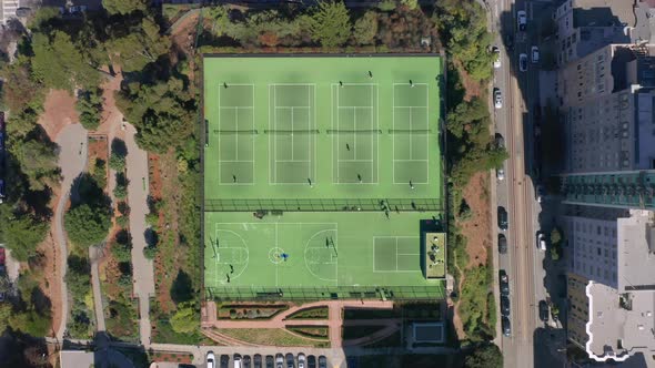 Overhead View on People Playing on Green Tennis and Basketball Courts  Aerial alt