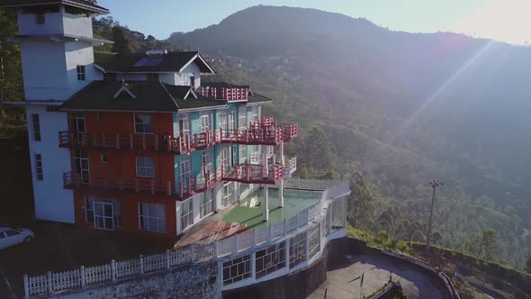 Lady Stands on Hotel Terrace in Middle of Tea Plantations