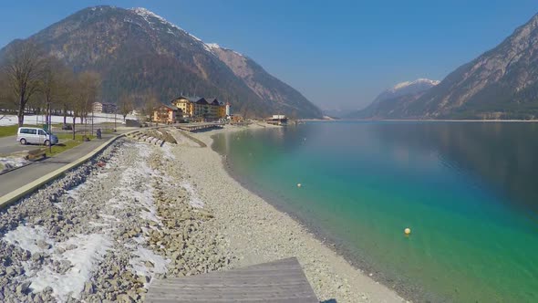 Aerial of Wooden Pier Near Lake, Snowy Mountains, Creative Fast Motion Effect