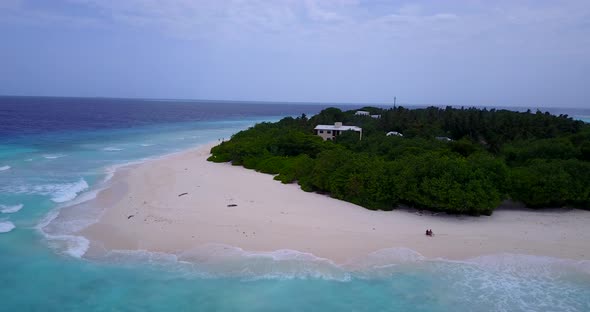 Wide birds eye travel shot of a paradise sunny white sand beach and aqua turquoise water background 