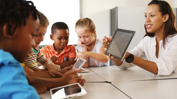 Teacher teaching kid on digital tablet in library