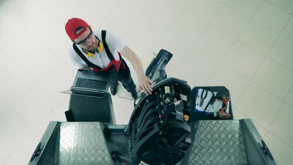 Specialist with a Laptop Is Repairing Speedboat's Motor