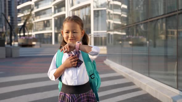 Child Girl in Uniform Is Going To School and Talking on Her Wrist Smart Watches