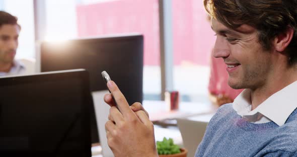 Businessman using mobile phone at desk