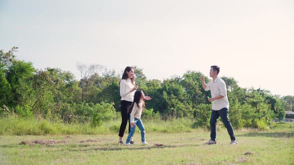 happy family life concept. Asian parents and the little girl enjoying and fun playing soap bubbles.