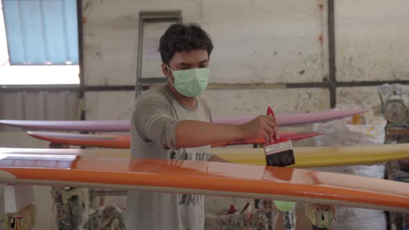 Young Indonesian Man Making Surfboard