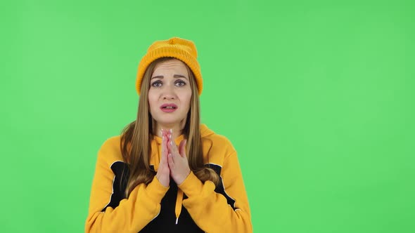 Portrait of Modern Girl in Yellow Hat Is Looking with Sympathetically, Folded Arms. Green Screen