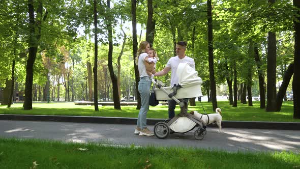 Lovely family with sweet little baby and pet in park