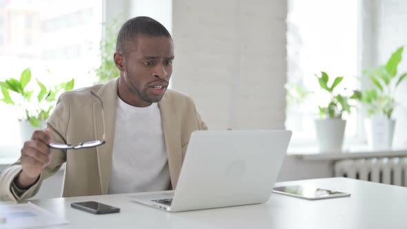 African Man Reacting to Loss While Using Laptop