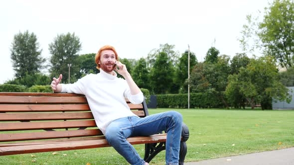 Attending Phone Call, Communicating, Sitting on Bench in Park