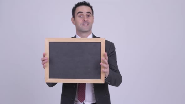 Happy Handsome Businessman Smiling While Showing Blackboard