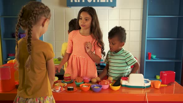 Kids Playing with Toy Kitchen in Kindergarten