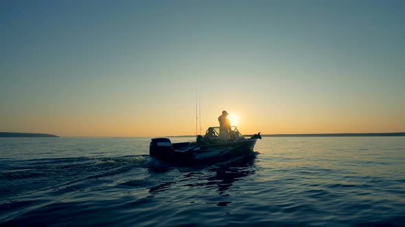 Fishermen Are Sailing Across Water During Sunrise