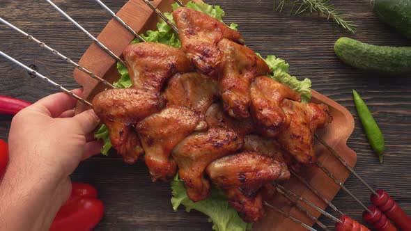 Top View of a Wooden Plate Full of Delicious Fried Chicken Wings on the Skewers