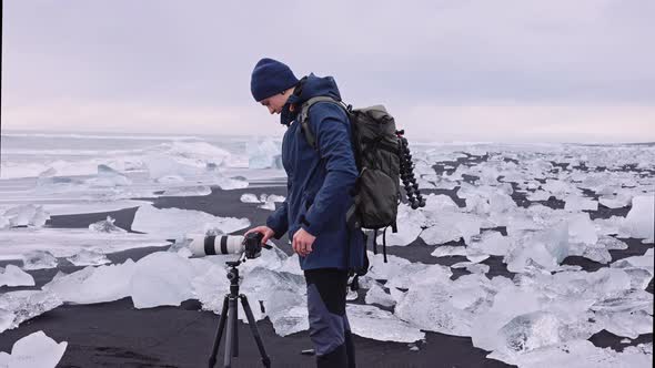 Photographer on Diamond Beach Near Glacier Lagoon of Iceland