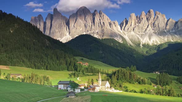 View of Dolomites at Santa Magdalena, Italy. Foothills Are Covered with Green Forest. Church and a