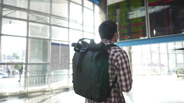 Caucasian Male Traveler in Medical Mask Takes Out Passport and Ticket From Back Pocket of Jeans in