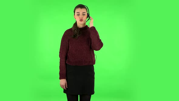 Young Girl Talking on Headphones, Call Center. Green Screen