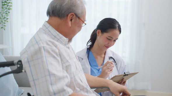 Asian caregiver nurse examine and listen to senior man patient at home.