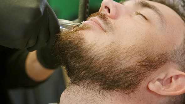 Barber Hands Hold Special Tool and Trim Customer Beard