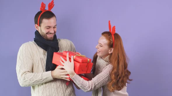 Young Handsome Guy Awkwardly Gives a Variety of Christmas Gifts To His Girlfriend