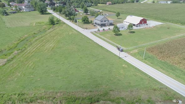 Aerial View of Following an Amish Horse and Buggy Down the Road in the Amish Countryside