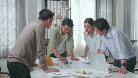 Group Of Asian Engineers Discuss About Work On The Tablet At The Office