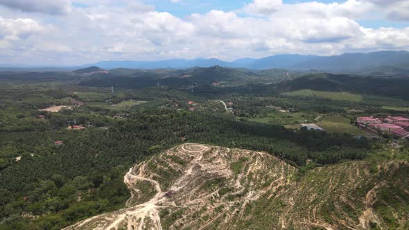 Aerial view of forest, hills, mountain, clear sky and village in Alor Gajah