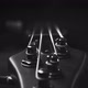 A headstock of a fretless electric bass guitar on the dark background, black and white - VideoHive Item for Sale