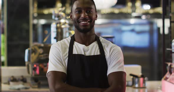 Portrait of african american barista smiling to camera wearing apron in cafe