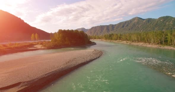 UHD Aerial View. Low Flight Over Fresh Cold Mountain River at Sunny Summer Morning. Green Trees and