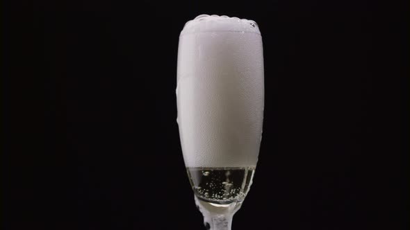 Waiter Pours the Champagne From the Bottle Into the Glass. Black Background