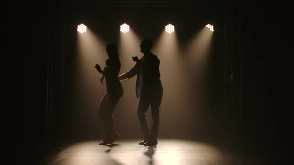 Young Couple Dancing Latin Music. Bachata, Merengue, Salsa. Shot in a Dark Studio with Neon Lights