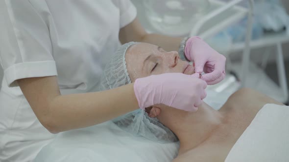 Cosmetologist Gives Facial Massage to Young Woman Without Makeup