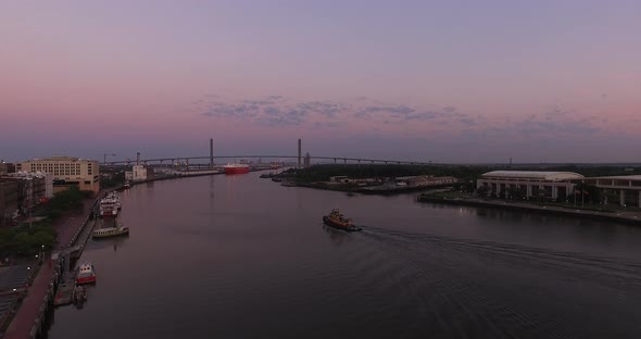 Tugboat on Savannah River with City and Bridge Aerial