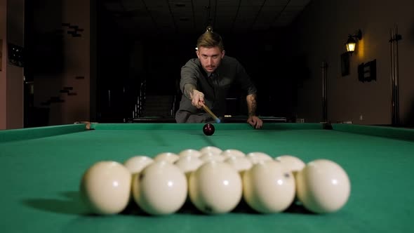 Young Successful Handsome Man Playing in Russian Pool at Bar with Friends