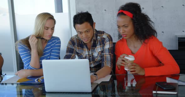 Executives sitting at table and working on laptop in modern office 4k