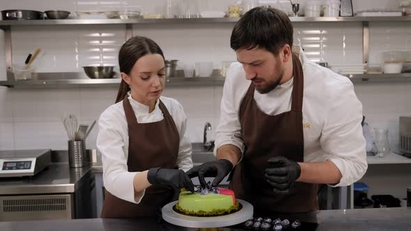 Two Pastry Chefs Decorate a Mousse Cake with a Mirror Glaze with Chocolates