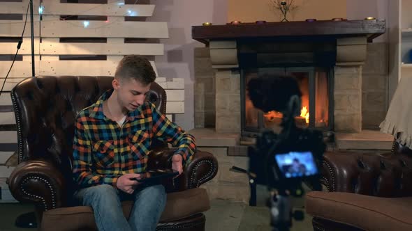 Teenager Sitting in Front of Home Video Camera and Speaking Something During Shooting