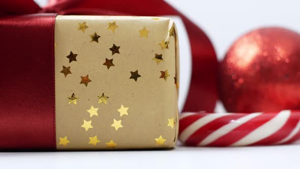 Christmas gift composition with red bow, Christmas tree balls and caramel cane.