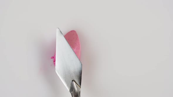 Smearing Pink Lipstick with Spatula Closeup