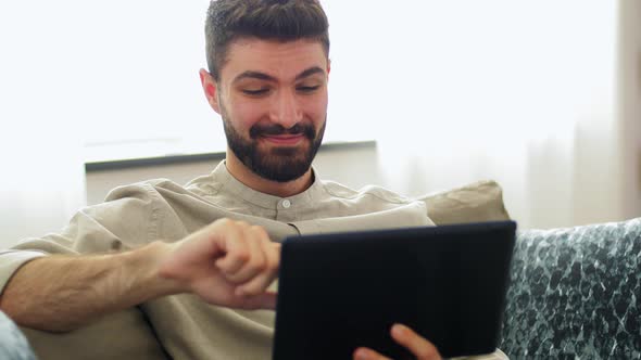 Smiling Man with Tablet Computer at Home