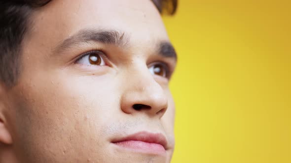 Extreme Close Up Portrait of Young Inspired Caucasian Man Looking Up with Delight and Smiling Empty