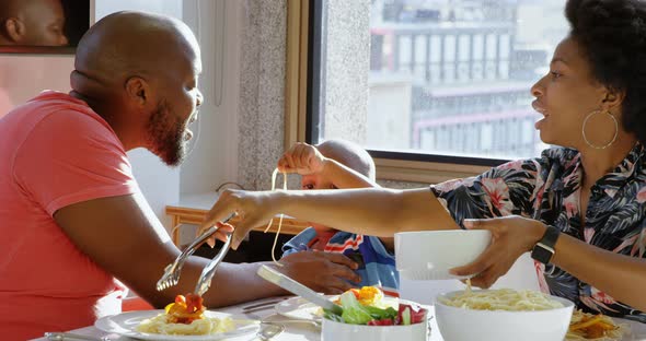 Family having food at dining table in a comfortable home 4k