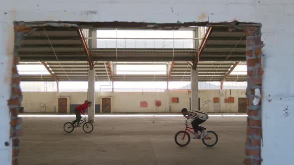 BMX riders in an empty warehouse