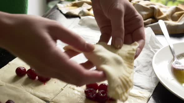 Mother cooking homemade cookies with cherry at home