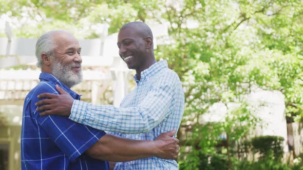 African American father and adult son embracing