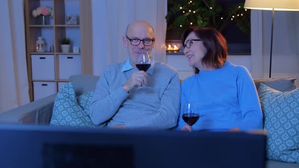 Happy Senior Couple Drink Red Wine and Watch Tv