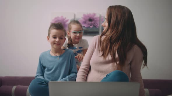 Woman with Children Video Call on Laptop